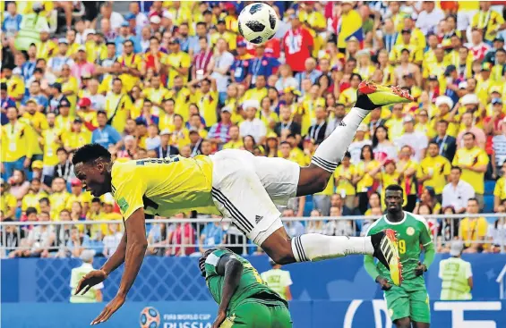  ?? Picture:AFP PHOTO /LUIS ACOSTA ?? LEAP OF FAITH: Colombia’s defender Yerry Mina, top, jumps over Senegal’s forward Sadio Mane during their Russia 2018 World Cup Group H football match at the Samara Arena yesterday