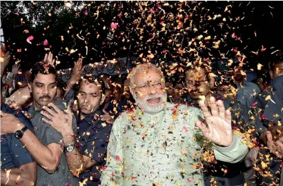  ??  ?? Prime Minister Narendra Modi being welcomed with petals at the party headquarte­rs to celebrate victory in New Delhi on Sunday. — PTI