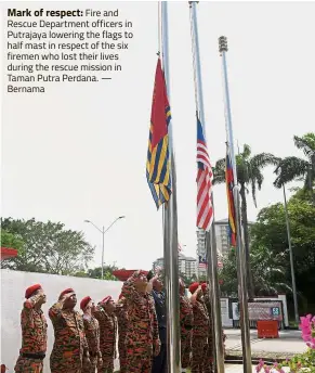  ??  ?? Mark of respect: Fire and Rescue Department officers in Putrajaya lowering the flags to half mast in respect of the six firemen who lost their lives during the rescue mission in Taman Putra Perdana. — Bernama