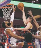  ?? CARLOS OSORIO/THE ASSOCIATED PRESS ?? Pistons center Andre Drummond, left, prepares to swat the ball away from Trail Blazers center Zach Collins during the first half of Monday’s game in Detroit.