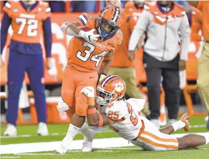  ?? ADRIAN KRAUS/AP ?? Syracuse running back Sean Tucker, tackled by Clemson safety Jalyn Phillips on Oct. 15, averages 135.4 rushing yards and has scored 11 touchdowns this season. The Orange will visit Virginia Tech today.