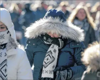  ?? AP PHOTO ?? Pedestrian­s try to keep warm while walking in New York’s Times Square, Wednesday, Dec. 27, 2017. Freezing temperatur­es and below-zero wind chills socked much of the northern United States on Wednesday, and the snow-hardened city of Erie, Pa., dug out...