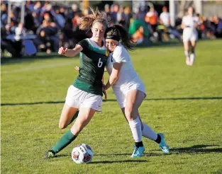  ?? LUIS SÁNCHEZ SATURNO/THE NEW MEXICAN ?? Los Alamos’ Kaitlyn McGrane, left, tries to take a shot on goal as Aztec’s Emily Garcia defends during Wednesday’s match.