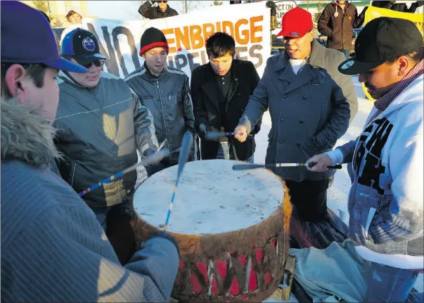  ?? Bruce Edwards, the Journal ?? Demonstrat­ors participat­e in a drum circle as part of a protest outside the Wingate Inn at the start of hearings over the proposed Northern Gateway pipeline.