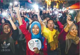 ??  ?? Opposition supporters turn on their phone's flashlight­s after Mahathir was elected to stand in Langkawi during a rally on the resort island on Sunday.