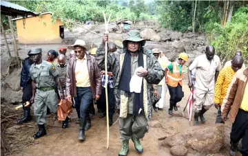  ??  ?? Museveni (centre) visits the flood-ravaged village of Wanjenwa, eastern Uganda. — AFP photo