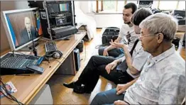  ?? ALEXANDER ZEMLIANICH­ENKO/AP ?? Office employees in Moscow watch President Vladimir Putin’s televised address Wednesday regarding increasing the age of pension eligibilit­y.