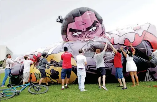  ?? Reuters ?? ↑
Activists and members of social organisati­ons inflate a doll depicting Brazil’s President Jair Bolsonaro during a protest demanding his impeachmen­t in Brasilia, Brazil, on Sunday.