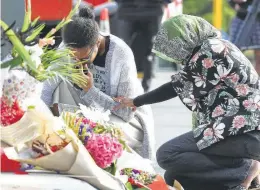  ?? Fiona Goodall / Getty Images ?? Residents place flowers in tribute to those killed and injured near Al Noor Mosque in Christchur­ch, New Zealand. At least 49 people were confirmed dead, with more than 40 people injured following attacks on two mosques in the city.