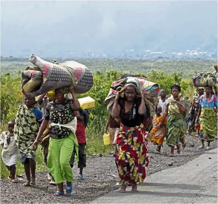  ??  ?? A 2012 file photo of villagers fleeing their homes to avoid the fighting between rebels and Congolese government troops. Tens of thousands of residents fled with only what they could carry. They’re returning to their homes now but without food crops, they face starvation.