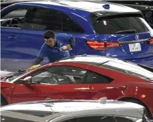  ??  ?? TOUCH-UP: Luis Romero of Cosmetic Car Care cleans a 2019 Acura NSX before today’s opening day at the auto show.