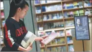  ?? LONG WEI / FOR CHINA DAILY ?? A reader selects books written by Louis Cha at a display set up to honor the novelist at a bookstore in Hangzhou, Zhejiang province, on Wednesday.