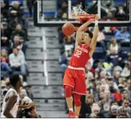  ?? JESSICA HILL — THE ASSOCIATED PRESS ?? Houston’s Rob Gray reacts while dunking the ball as UConn’s Kentan Facey looks on, in the first half of the Huskies’ loss to the Cougars.