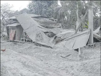  ?? Aaron Favila The Associated Press ?? A damaged house sags Saturday at a village beside Taal volcano in the Philippine­s.