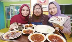  ?? PIC BY ZAMAN HURI ISA ?? Nasi Lemak Bersinar employees showing the popular dish with several types of sambal.