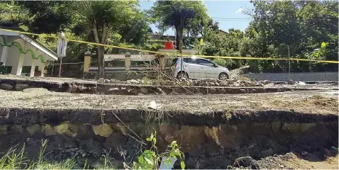  ?? AJI PUTRA/JAWA POS RADAR PONOROGO ?? HATI-HATI: Sistem buka tutup diberlakuk­an polisi di jalan raya Ponorogo–Pacitan, Desa Wates, Slahung, setelah ambles kemarin.