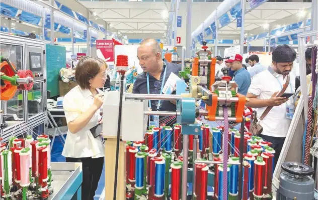  ?? Reuters ?? ↑ People visit the booth of a braiding machine producer from Xuzhou at the China Import and Export Fair in Guangzhou, China, on Tuesday.