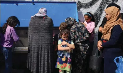  ?? Photograph: Mahmud Hams/AFP/Getty Images ?? The UN agency for Palestinia­n refugees providing water for displaced people. Since Saturday, limited amounts of bottled water have entered Gaza in aid convoys.