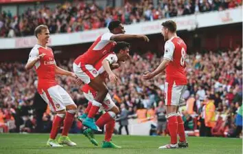  ?? AFP ?? Arsenal’s Aaron Ramsey (right) celebrates after scoring the third goal against Everton on Sunday. Arsenal face Chelsea amid feverish speculatio­n about coach Arsene Wenger’s future.