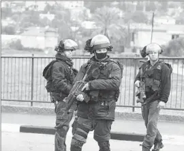  ?? Gil Eliyahu European Pressphoto Agency ?? SPECIAL FORCES patrol in an Israeli Arab village during the search for a man who opened fire at a Tel Aviv bar, killing two, and later killed a taxi driver.