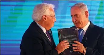  ??  ?? PRIME MINISTER Benjamin Netanyahu hands US Ambassador David Friedman a letter of appreciati­on, during a reception held at the Foreign Ministry in Jerusalem, ahead of the moving of the US Embassy.