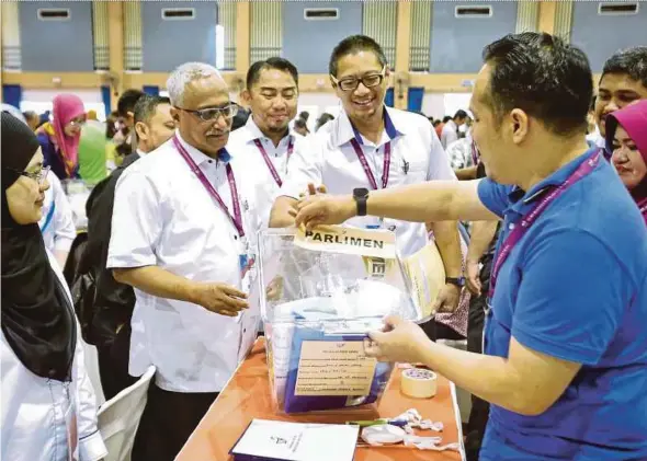  ?? PIC BY KHAIRULL AZRY BIDIN. ?? Election Commission deputy chairman Dr Azmi Sharom (second from right) at the ballot counting centre at SMJK Tiong Hua in Sandakan yesterday. With him is EC secretary Datuk Mohamed Elias Abu Bakar (second from left).