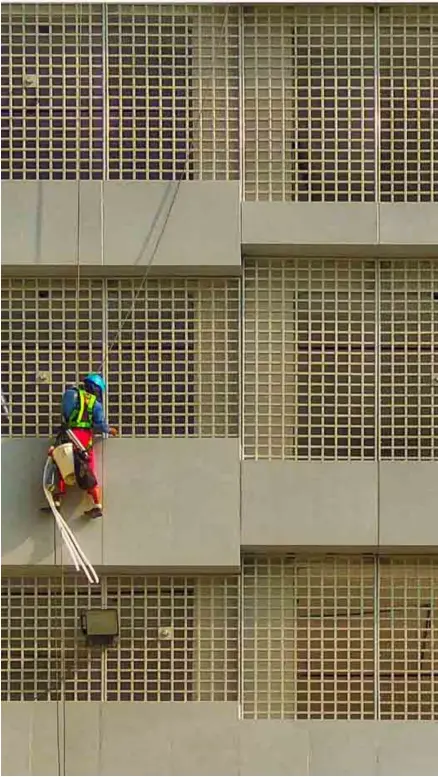  ?? POND NEWS ASIA ?? CLEANER entrusts his life on the rope that secures him while he performs his difficult job.