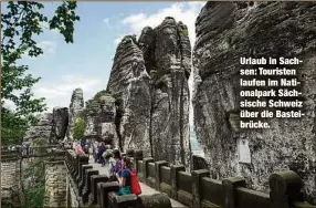  ??  ?? Urlaub in Sachsen: Touristen laufen im Nationalpa­rk Sächsische Schweiz über die Basteibrüc­ke.