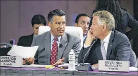  ?? STEPHAN SAVOIA / AP ?? Nevada Republican Gov. Brian Sandoval (left) and Virginia Democratic Gov. Terence McAuliffe at the National Governors Associatio­n’s meeting Saturday in Providence, R.I. Sandoval has questioned cuts in the Senate health plan.