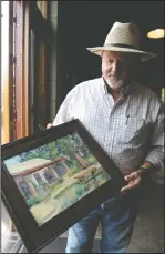  ??  ?? Klinker Brick Winery co-owner Steve Felten holds a painting of the winery’s patio by Mary Doucette at the Lodi winery on Wednesday.