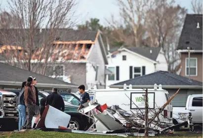  ?? JOSEPH CRESS/IOWA CITY PRESS-CITIZEN ?? People stand amongst storm damaged buildings after a tornado warning in Johnson County on March 31 in Hills.