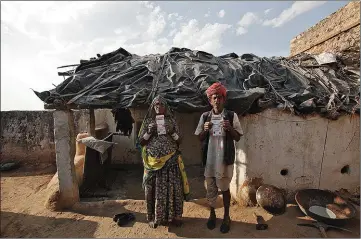  ??  ?? Ghewar Ram, 55 ans, et sa femme Champa Devi, 54 ans, montrant leur carte devant chez eux, à Merta, Rajasthan, en 2013.