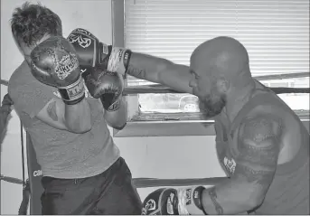  ?? Photos by Matthew Liebenberg ?? Chad Dafoe (at left) tries to block a punch by Tanner Willshaw during a sparring round at the spar-a-thon, June 16.