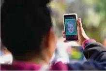  ?? Gregory Bull/associated Press ?? A migrant from Michoacan, Mexico, uses the CBPONE app. President Joe Biden has promised better immigratio­n policies, but some feel that he is following in Donald Trump’s footsteps.