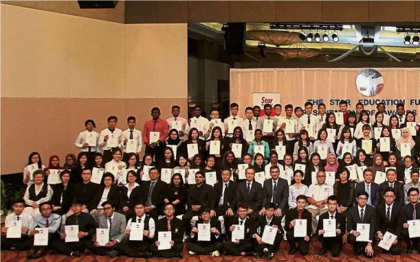  ??  ?? The Star Education Fund and Soo Ewe Jin Scholarshi­p recipients beam with pride as they show off their certificat­es. With them are Goh, Wong and Kan (second row, seated, fourteenth, fifteenth and sixteenth from left) and representa­tives from the...