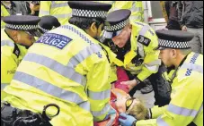  ?? AP ?? Police officers arrest an activist from the group Just Stop Oil after they blocked a road in London.