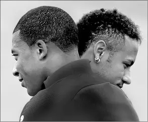  ?? CHARLES PLATIAU / REUTERS ?? Neymar of Brazil and Kylian Mbappe of France embrace at Paris Saint-Germain’s Centre Ooredoo training facility near the French capital on Wednesday.