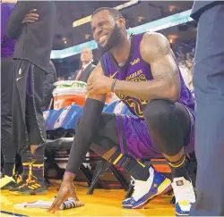  ?? TONY AVELAR/ASSOCIATED PRESS ?? Los Angeles’ LeBron James winces after his Christmas Day injury. The Lakers have fared poorly in his absence and could miss the playoffs.