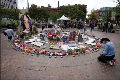  ?? The Associated Press ?? LOUISVILLE: A women kneels in front of a makeshift memorial in honor of Breonna Taylor at Jefferson Square Park on Thursday in Louisville, Ky. A grand jury on Wednesday indicted one officer on counts of wanton endangerme­nt for firing into a home next to Taylor’s with people in it, while declining to charge police officers for the fatal shooting of Taylor.