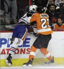  ?? MATT SLOCUM, THE ASSOCIATED PRESS ?? Philadelph­ia Flyers’ Brandon Manning jostles with Edmonton Oilers’ Connor McDavid in Philadelph­ia Thursday.