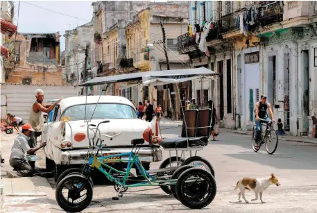  ??  ?? People go on with their daily lives in the sun-drenched backstreet­s of Havana yesterday as Miguel Diaz-Canel (inset, left) was formally named Cuba’s new president, succeeding Raúl Castro (inset, right), the brother of revolution­ary leader Fidel