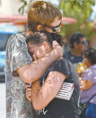  ??  ?? Kendall Long consuela a Kianna, quien estaba en la sección de congelados de la tienda Walmart en El Paso, Texas, donde ayer entró un sujeto armado con un rifle y comenzó a disparar.