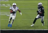  ?? ISAAC BREKKEN — THE ASSOCIATED PRESS ?? Indianapol­is Colts running back Jonathan Taylor (28) runs in for a touchdown against Las Vegas Raiders outside linebacker Cory Littleton (42) during the second half Sunday in Las Vegas.