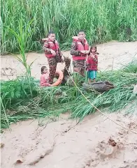  ??  ?? DUA kanak-kanak perempuan yang terperangk­ap di Sungai Pampang berjaya diselamatk­an oleh anggota bomba dengan menggunaka­n tali.