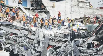  ??  ?? Members of rescue teams continue to search for people under the rubble of a collapsed building. — Reuters photo