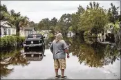  ?? NEW YORK TIMES ?? A resident looks out over floodwater­s that inundate a neighborho­od in Socastee, S.C. Along the coast, many streets remain impassable as towns struggle to rebuild after Hurricane Florence.