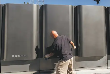  ?? Photos by Peter Prato / New York Times ?? Randy Eoff, a manufactur­ing specialist, cleans off the latest model of fuel cell generators at Bloom Energy in Sunnyvale. The company will install generators using fuel cells like the one below at a dozen data centers.