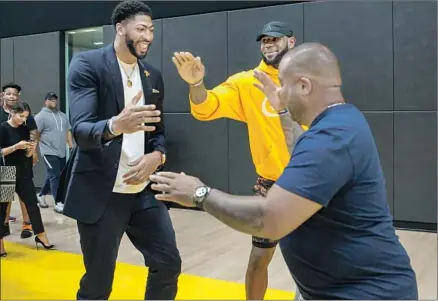  ?? Marcus Yam Los Angeles Times ?? ANTHONY DAVIS greets LeBron James’ friend Randy Mims, as James playfully tries to block them, after Davis was introduced Saturday at the Lakers’ training facility in El Segundo. The pairing of Davis and James has the Lakers talking about titles again.