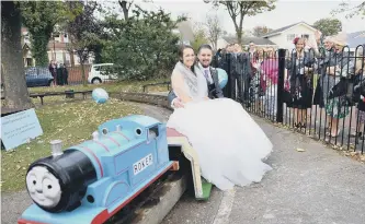  ??  ?? Wedding couple Chris and Rebecca Spokes on the miniature railway in Roker Park as they are waved off by their wedding guests.