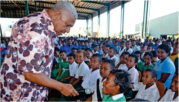  ?? Photo: Charles Chambers ?? Prime Minister Voreqe Bainimaram­a takes time off to interview a young landowner who was part of the large crowd at Tropik Wood Complex in Drasa, Lautoka, on August 4, 2017. The Prime Minister was there to distribute the Fiji Pine Lease Security Bonus...
